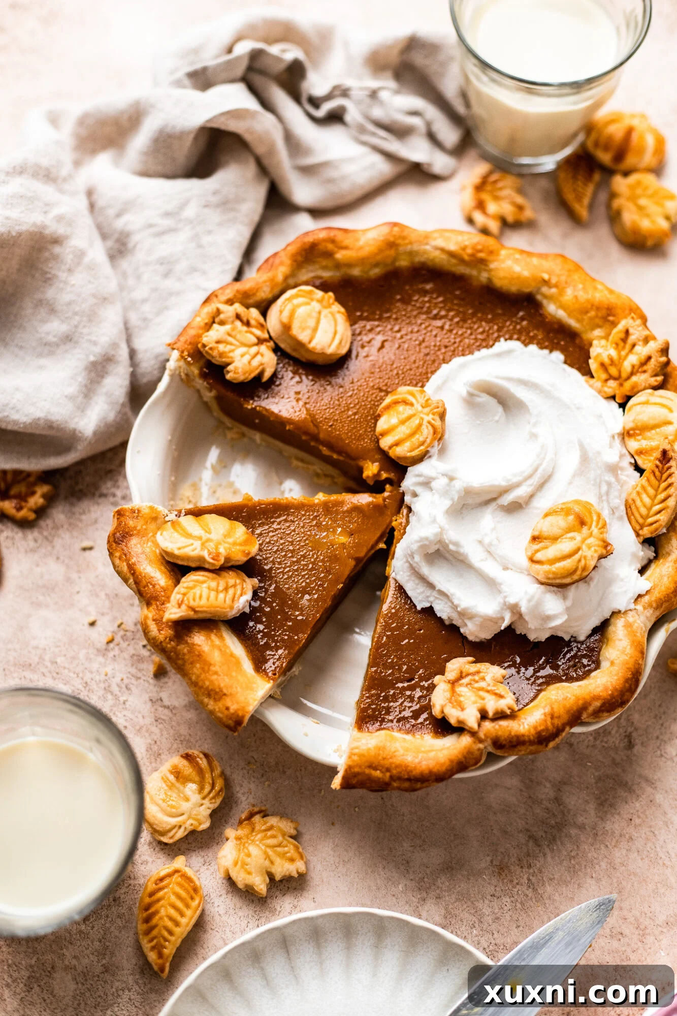 A perfectly sliced vegan pumpkin pie, showcasing its creamy filling and flaky crust.