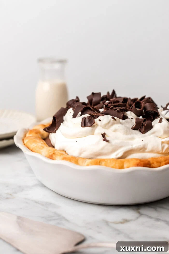 finished vegan chocolate cream pie on a table with a glass of milk