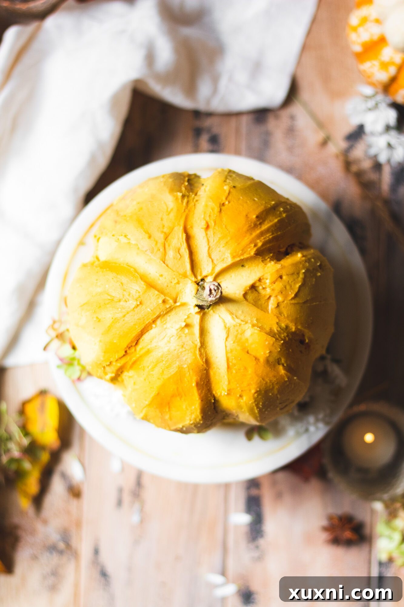 Overhead shot of the pumpkin-shaped chocolate cake, showcasing its perfect roundness and the beautiful texture of the dairy-free frosting.