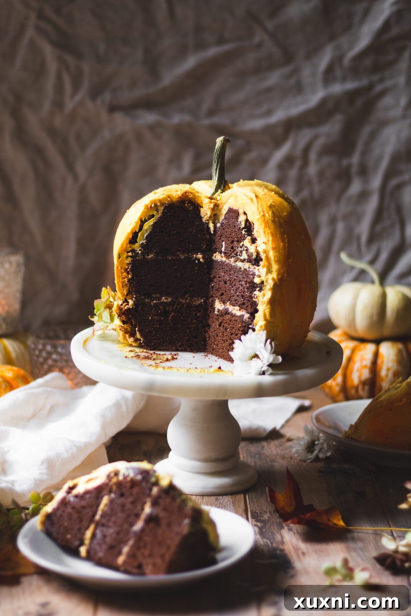 Another close-up of a sliced pumpkin cake, highlighting the rich chocolate sponge against the vibrant orange buttercream, making it irresistibly delicious.
