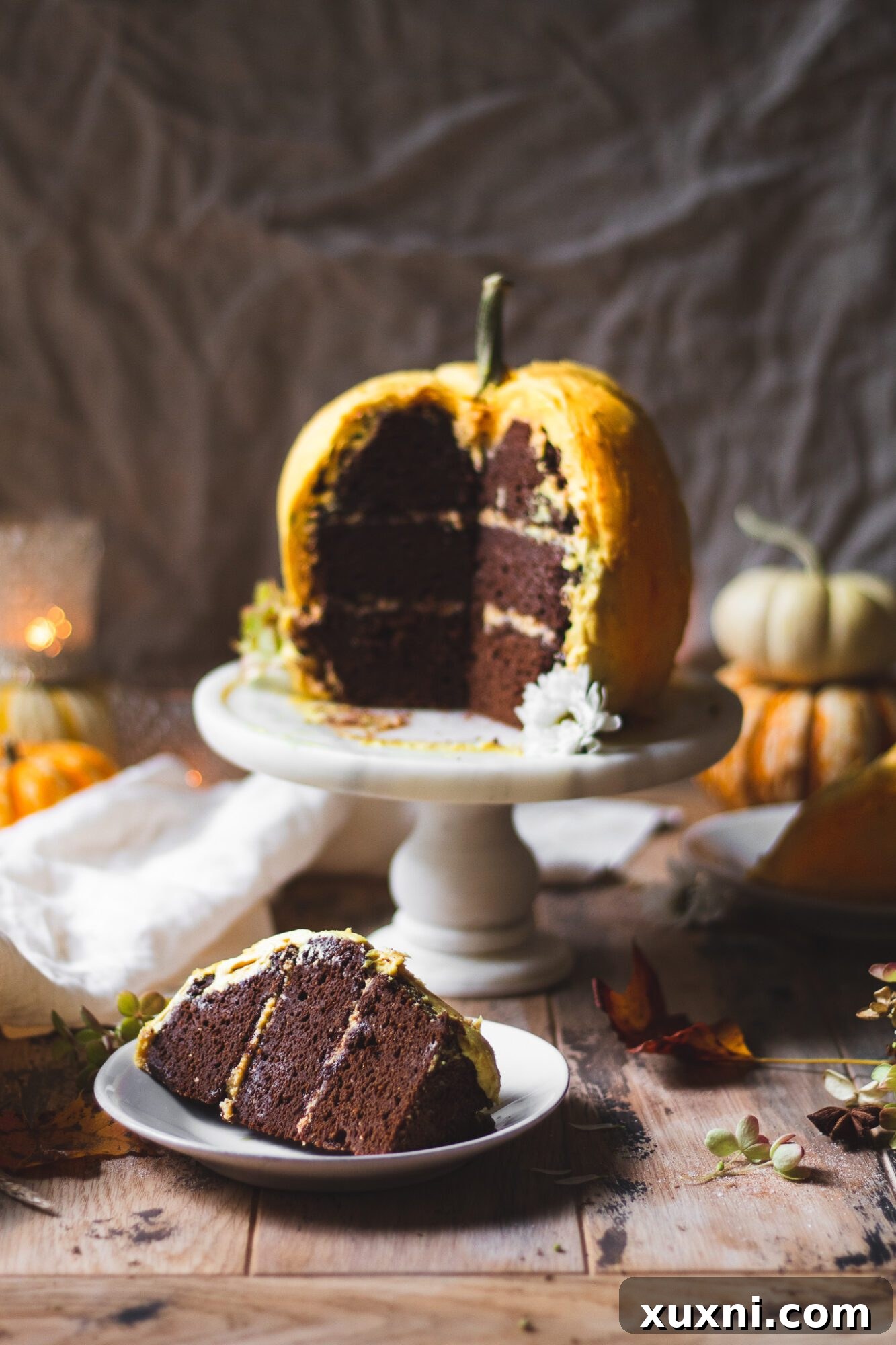 The fully decorated pumpkin-shaped vegan cake, complete with a stem, ready to be presented as a festive centerpiece.