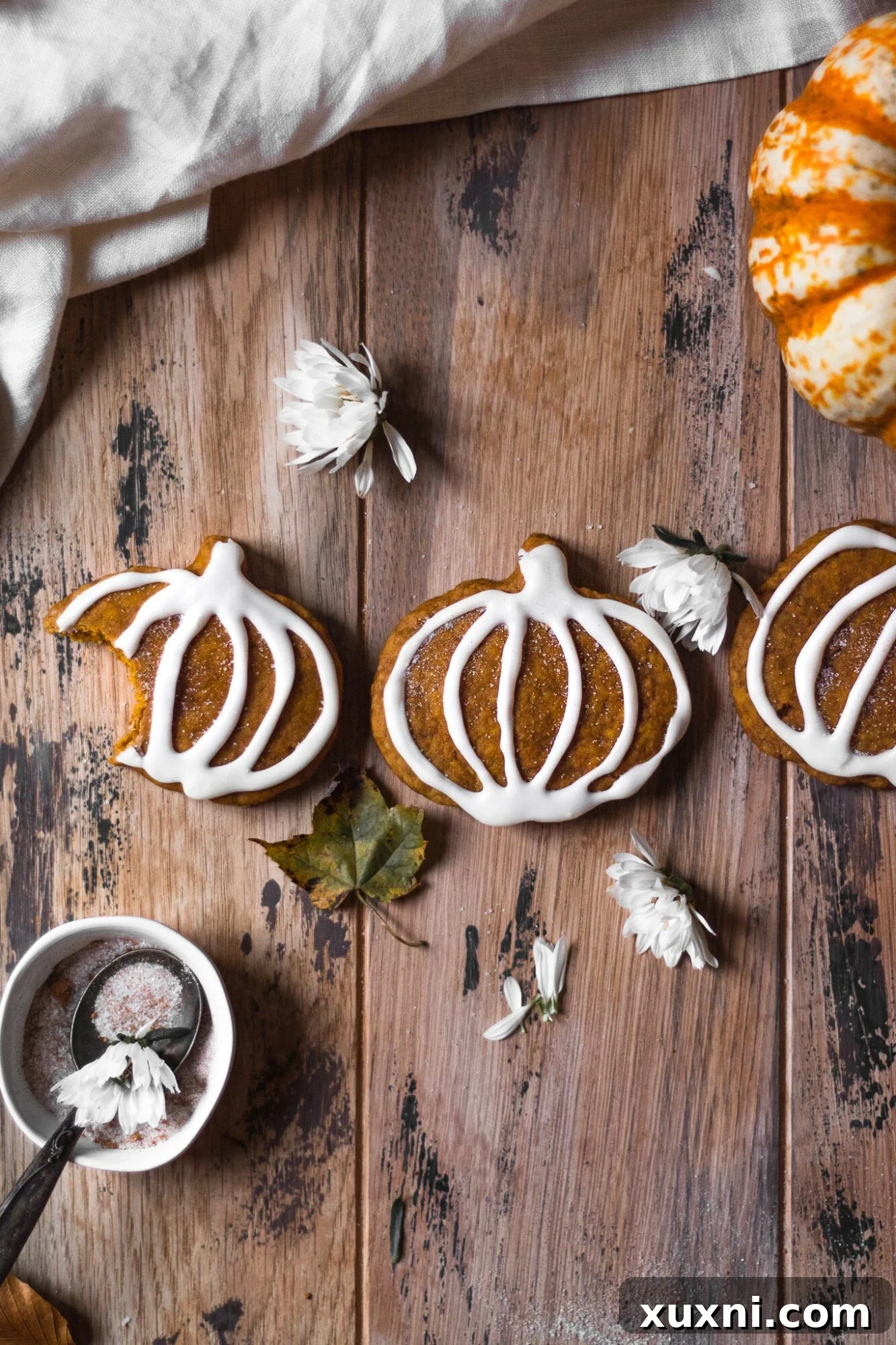 vegan pumpkin sugar cookie with a bite taken, showing soft interior