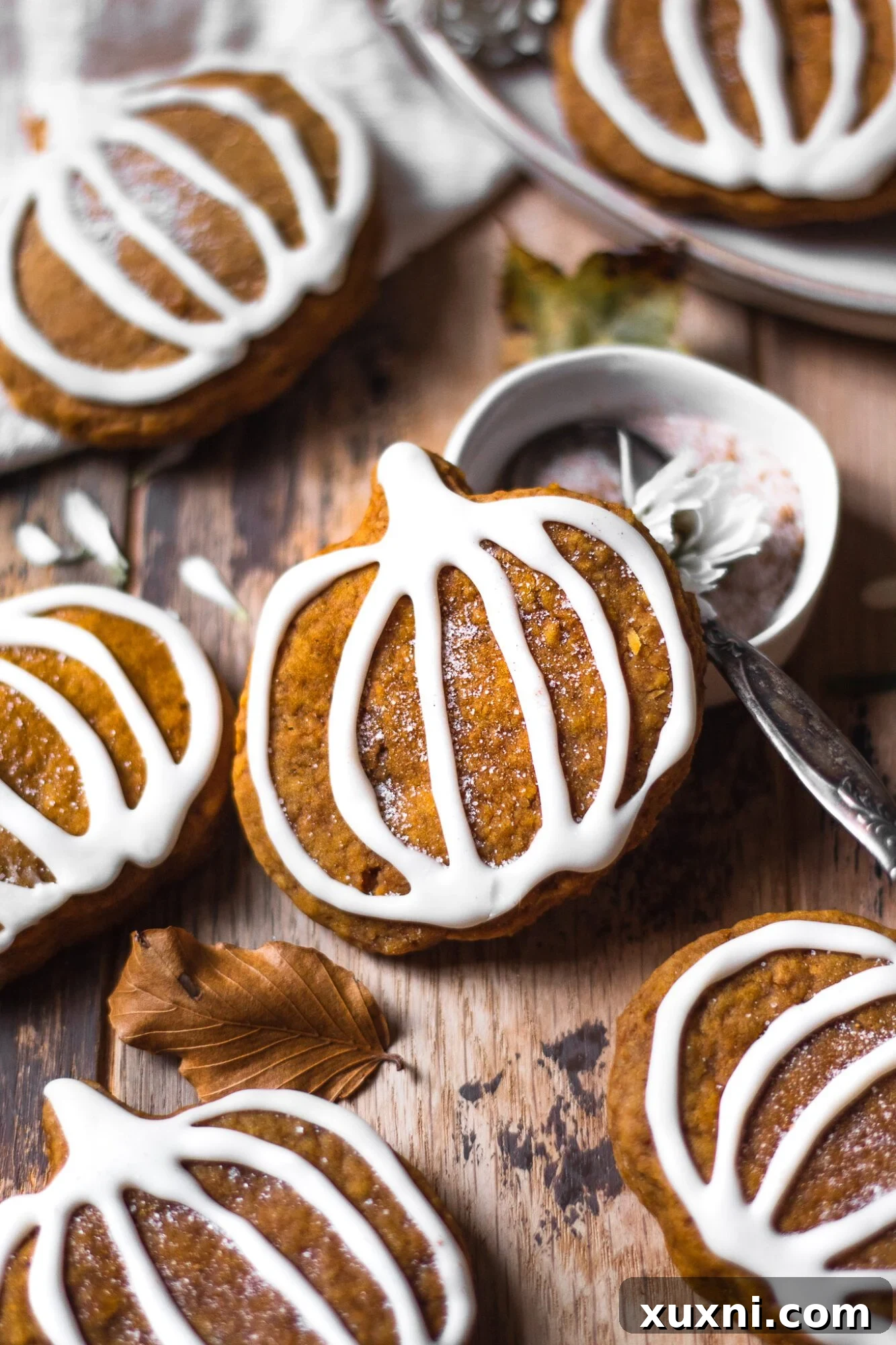 vegan pumpkin sugar cookie resting against a glass of plant-based milk
