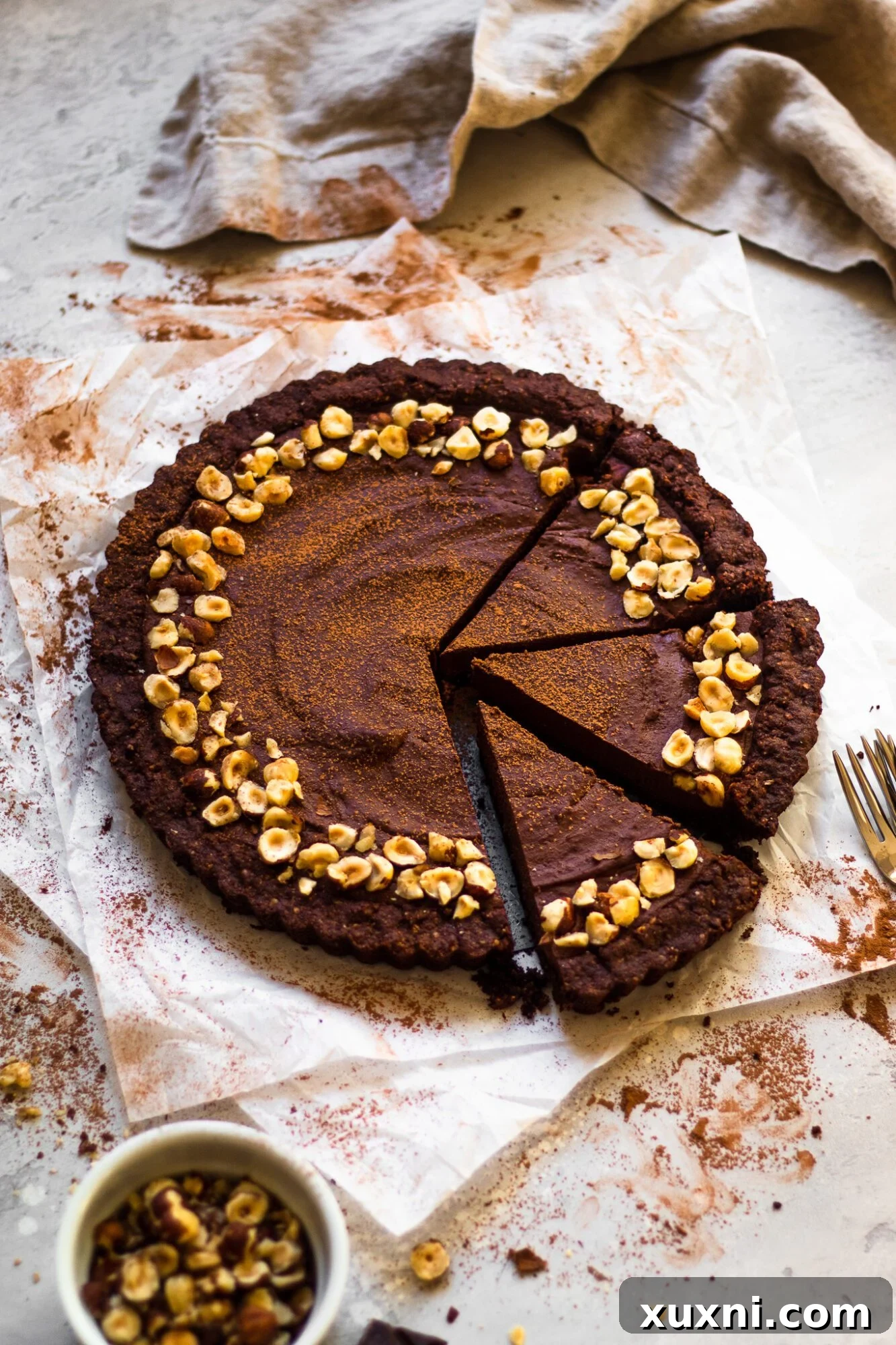 Overhead shot of several slices of vegan chocolate hazelnut tart arranged artfully, highlighting its appeal