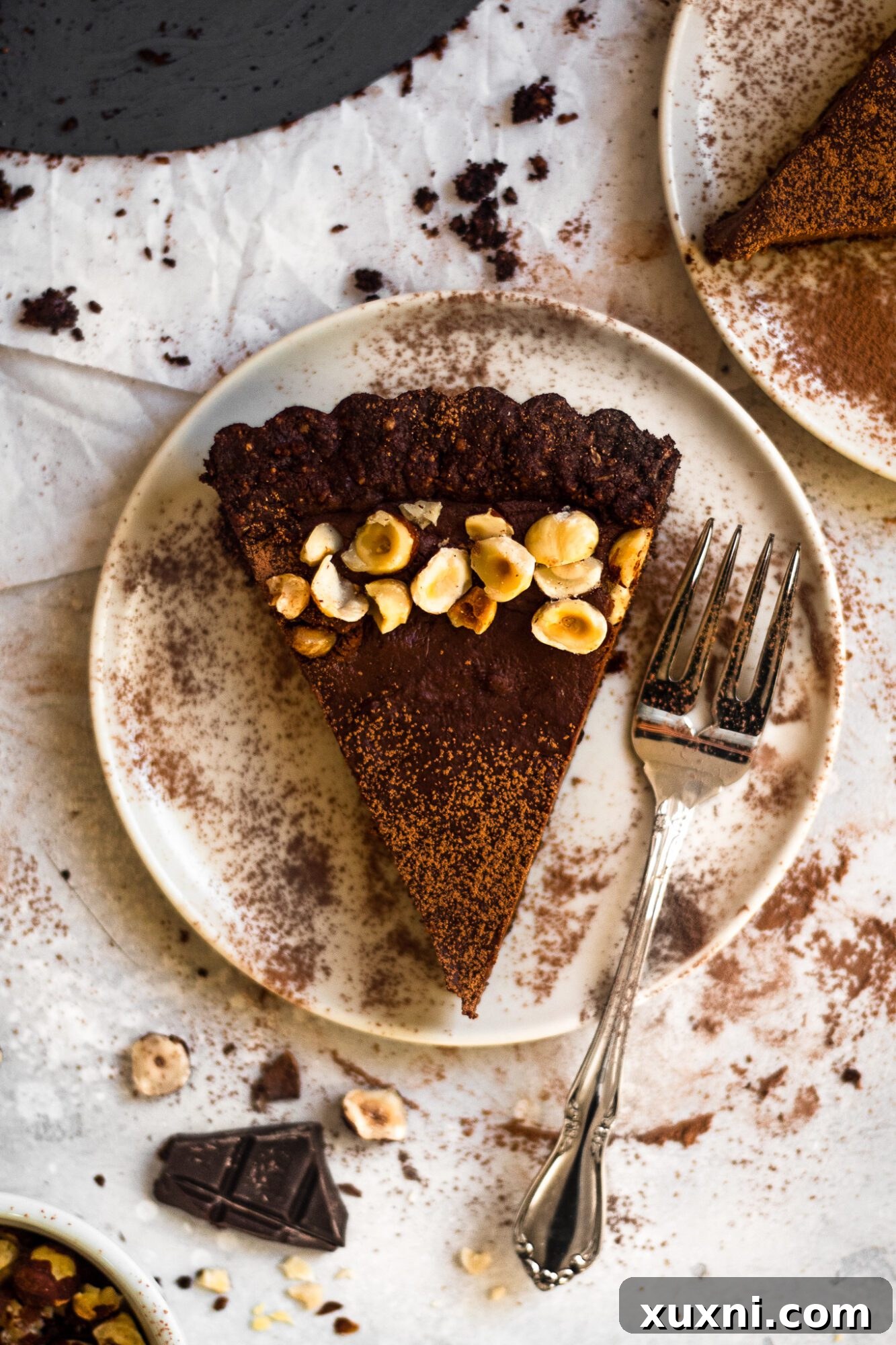 Overhead view of a whole vegan chocolate hazelnut tart with a perfect golden brown crust and smooth chocolate filling