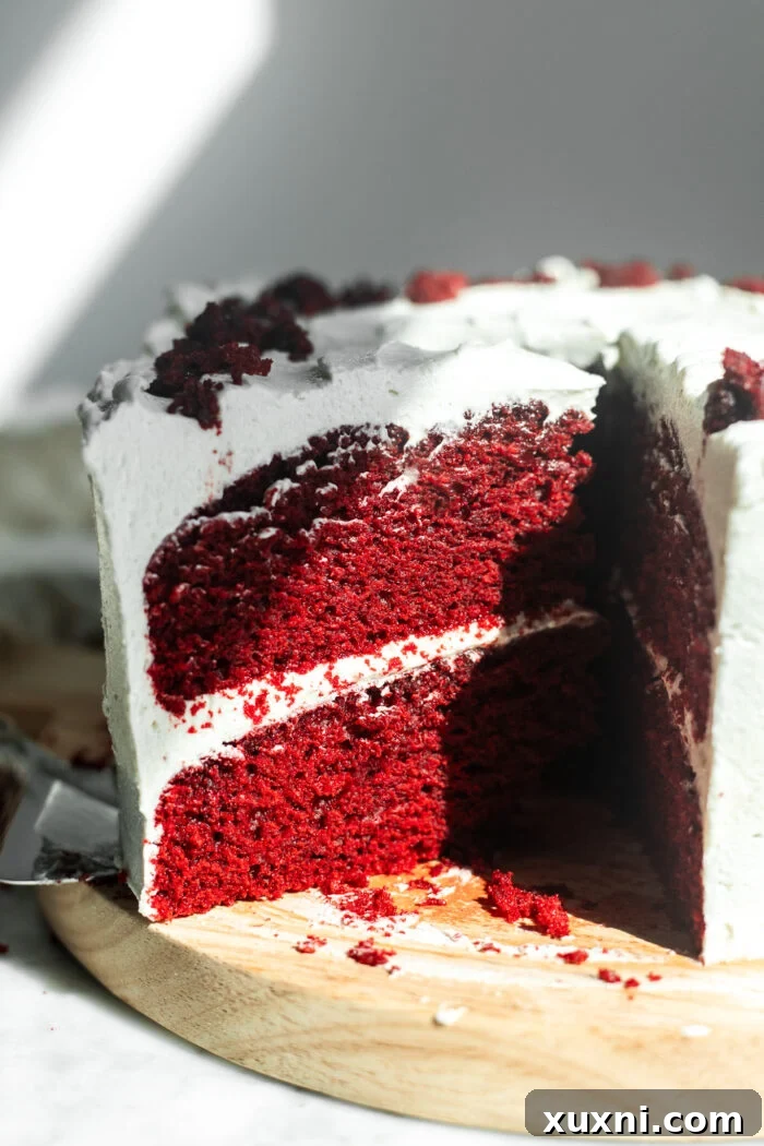 A beautiful slice of vegan red velvet cake presented on a cake board, ready to be enjoyed.