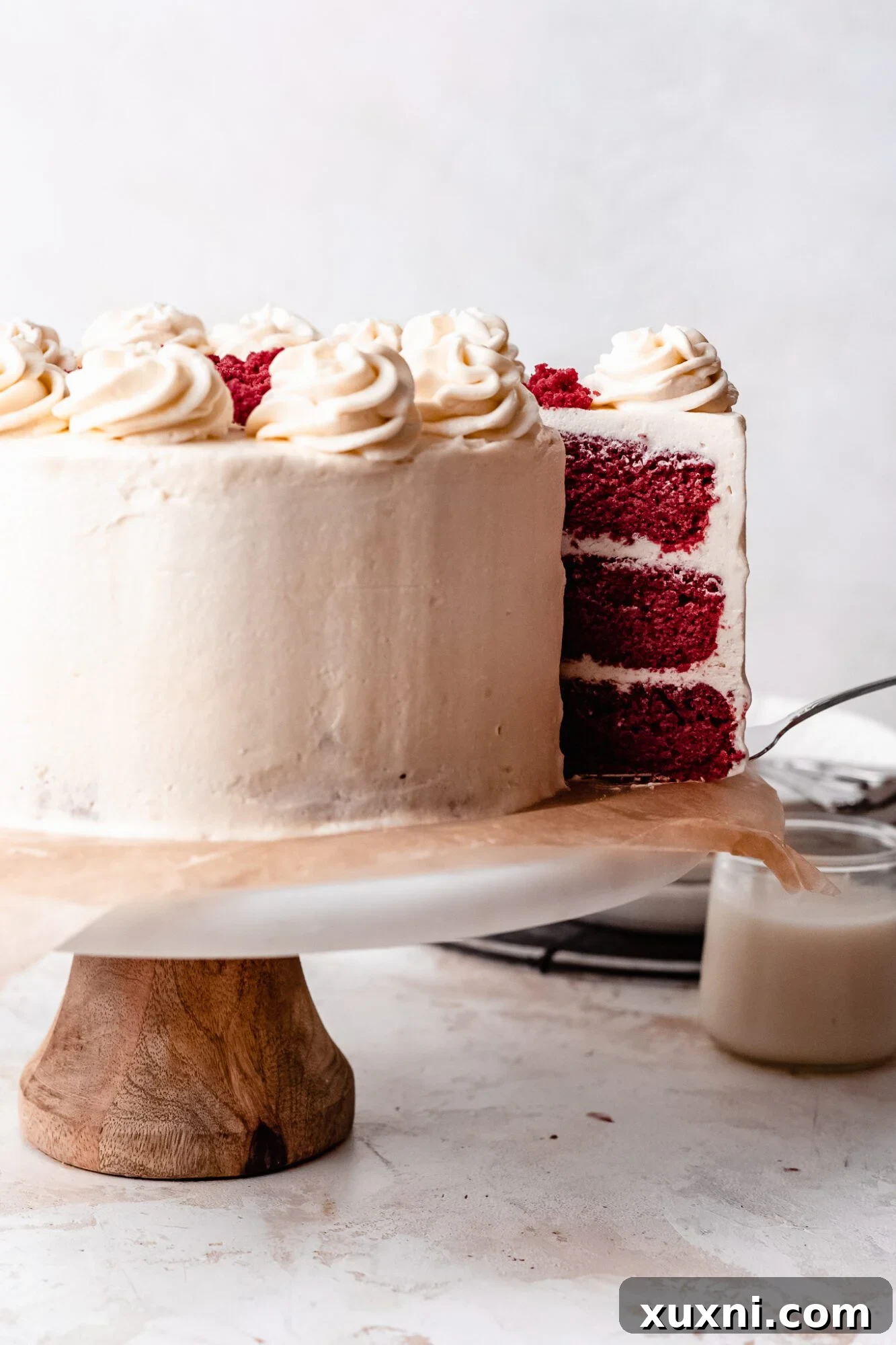 Another mouth-watering shot of a sliced vegan red velvet cake, showing the perfect crumb and layers of frosting.