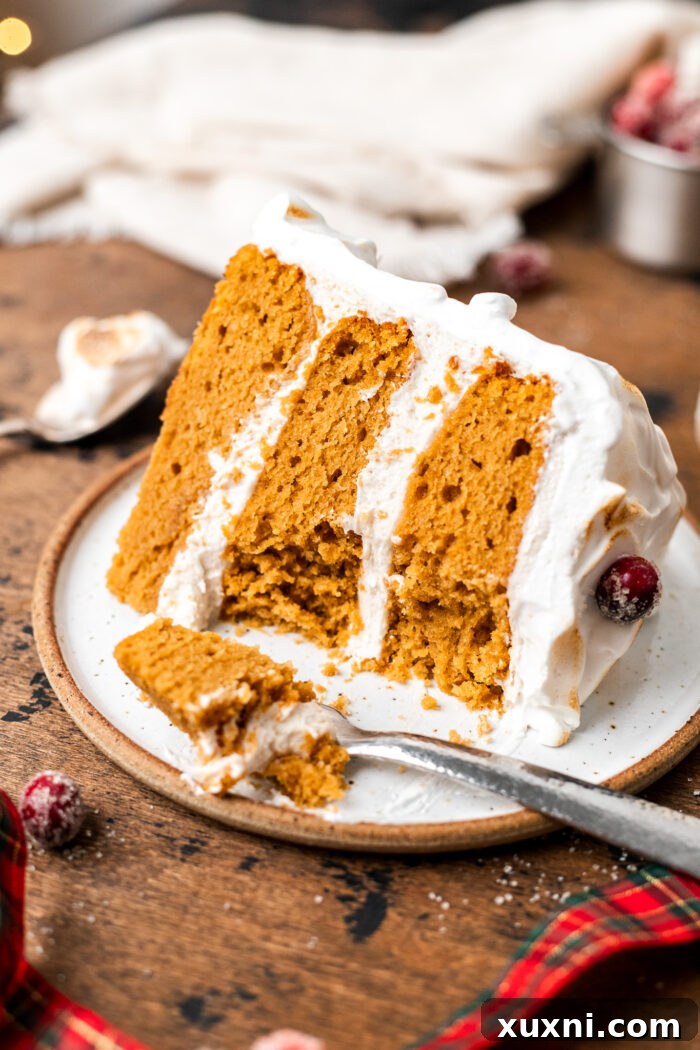 A close-up of a bitten slice of vegan sweet potato spice cake, highlighting its moist texture and delicious layers.