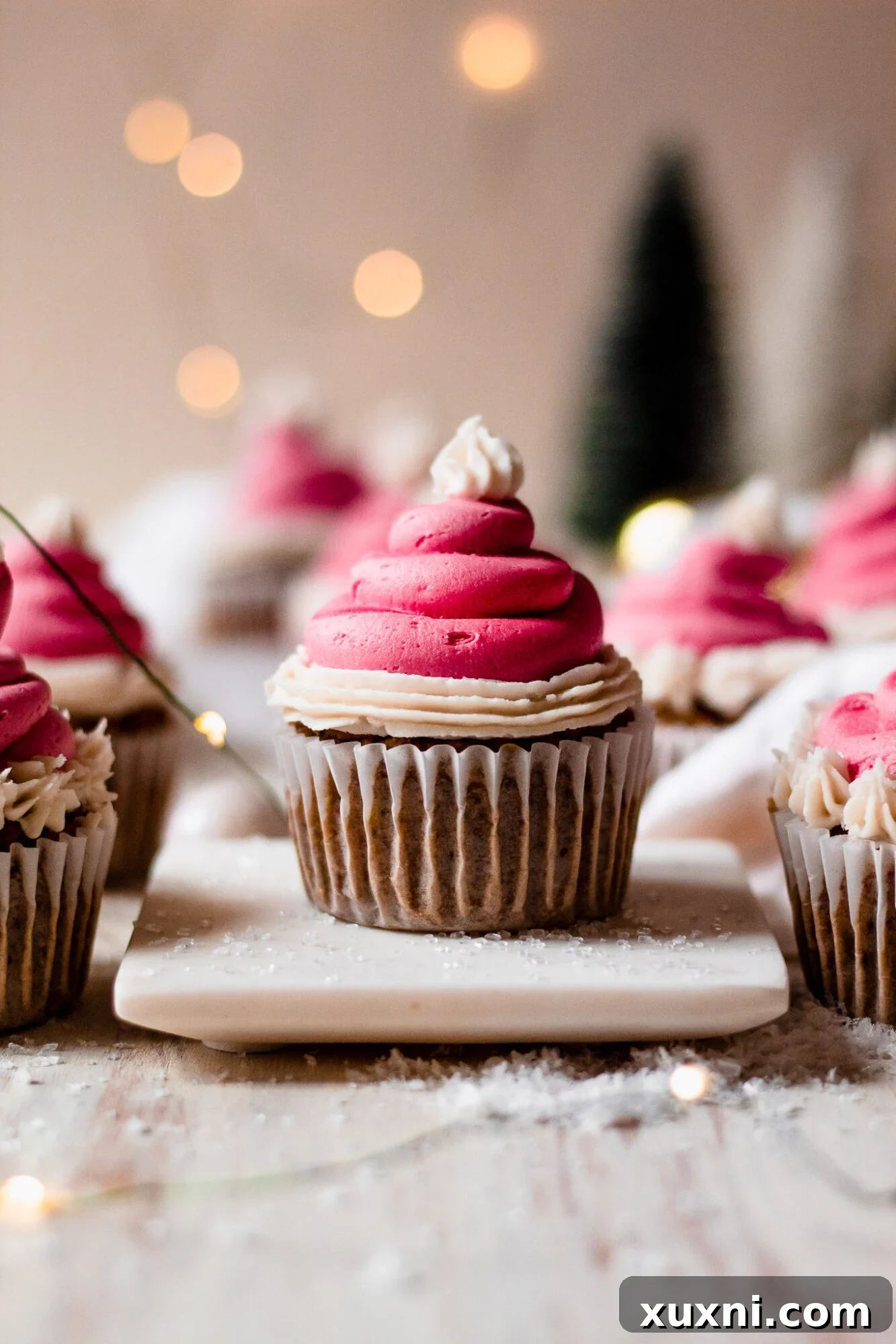 Festive Vegan Pistachio Santa Hat Cupcakes 11 A single beautifully decorated Christmas cupcake on a marble plate, showing off its green cake and perfect Santa hat frosting.