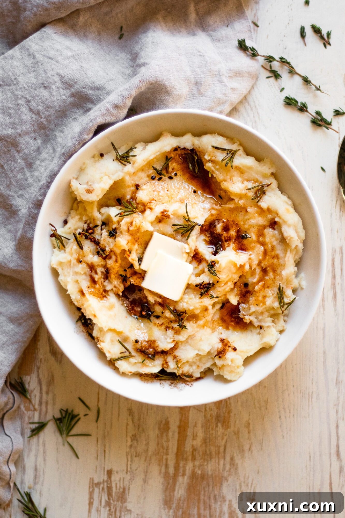 bowl of whole30 mashed potatoes, garnished with fresh herbs