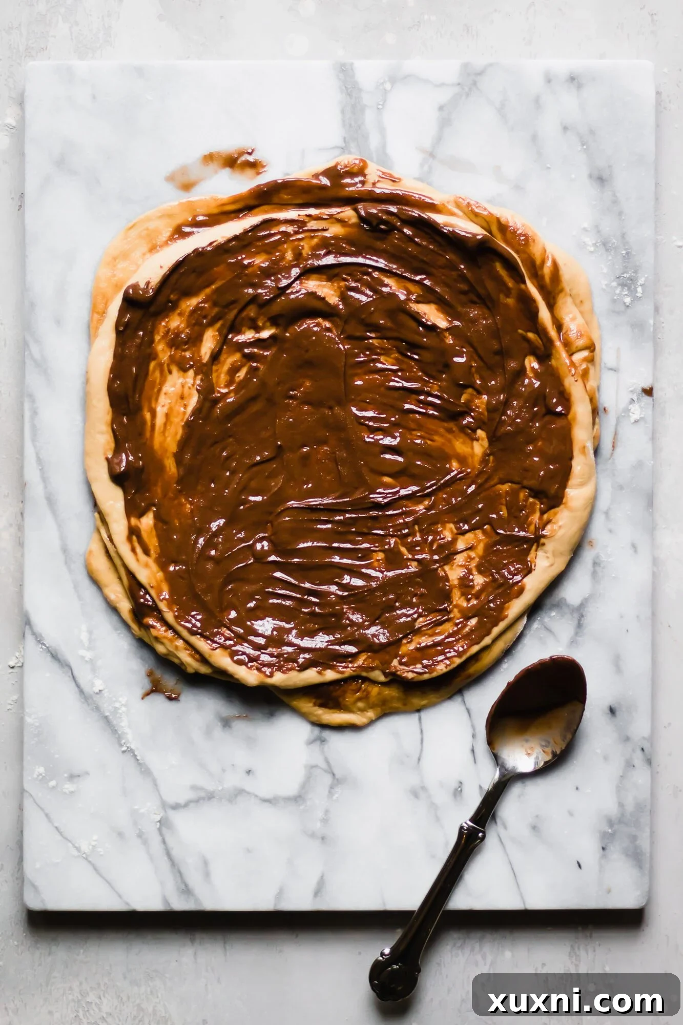 Full dough circle evenly coated with vegan chocolate hazelnut spread