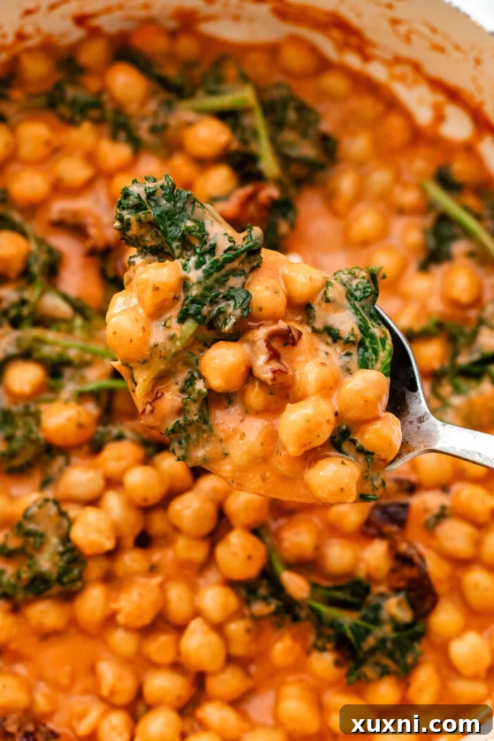 A close-up of Marry Me Chickpeas, generously scooped into a bowl, showcasing its creamy texture and vibrant ingredients.